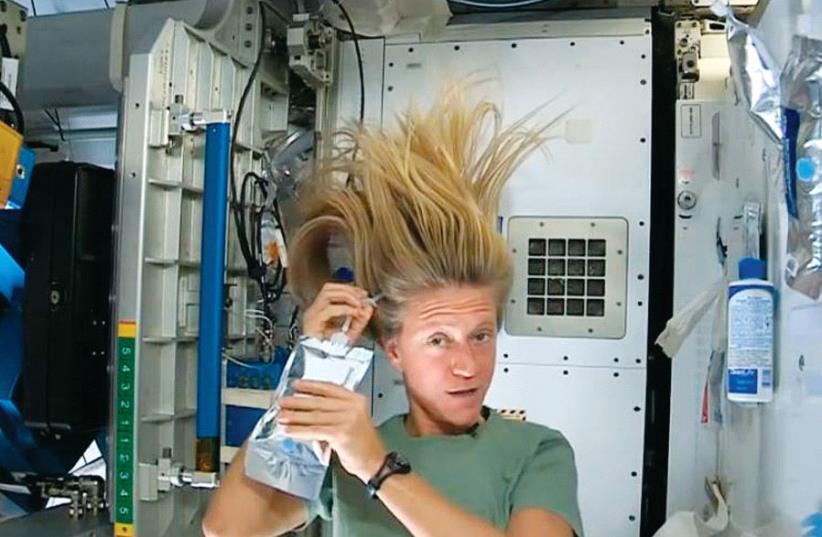 Nasa astronaut Karen Nyberg demonstrates how she washes her hair in zero gravity in outer space during a mission in 2013 (photo credit: NASA,REUTERS)