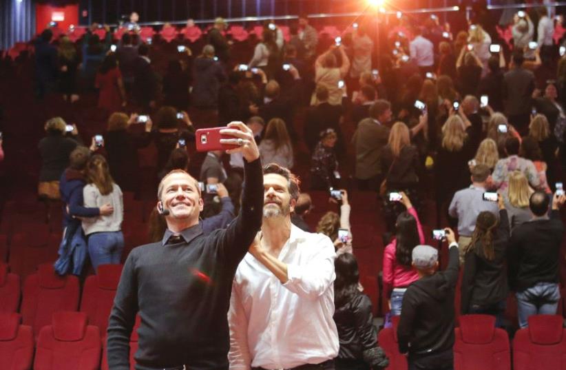 TBEX participants take a group selfie as visiting American actor Corin Nemic (left) and Israeli actor Ishai Golan do the same, at the conference opening party at Cinema City (photo credit: NOAM MOSKOVICH)