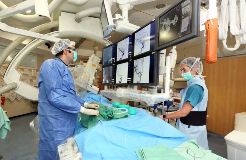 Dr. Eitan Abergel performing a brain catheterization. (photo credit: PIOTR FLITR)