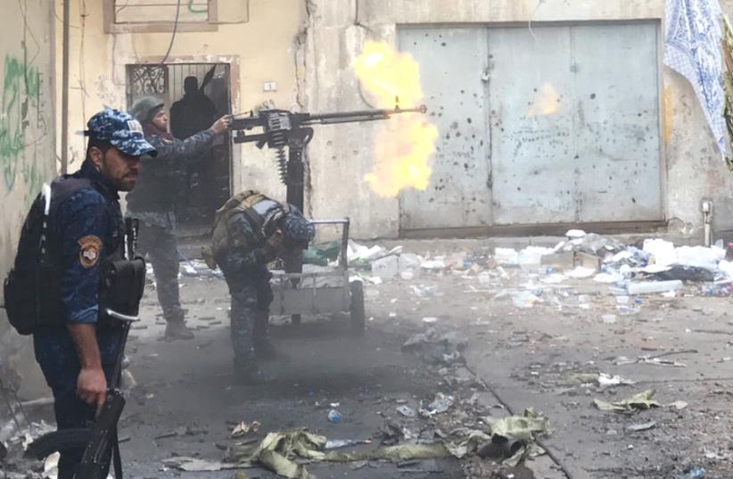 IRAQI SECURITY FORCES battle ISIS terrorists yesterday in western Mosul.  (photo credit: SETH J. FRANTZMAN)