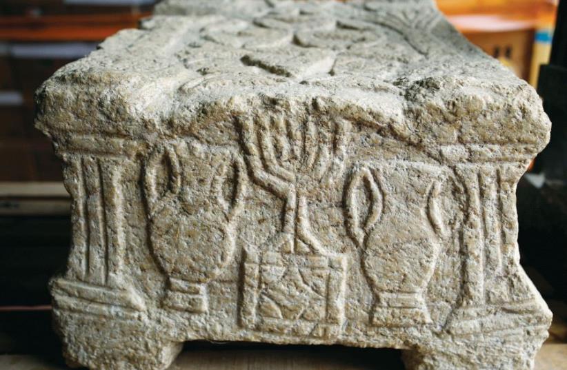 The Magdala Stone, one of the earliest known depictions of a menorah, estimated to be from the year 70 CE, is seen during a media tour at Israel’s National Treasures Storeroom, in Beit Shemesh (photo credit: REUTERS)