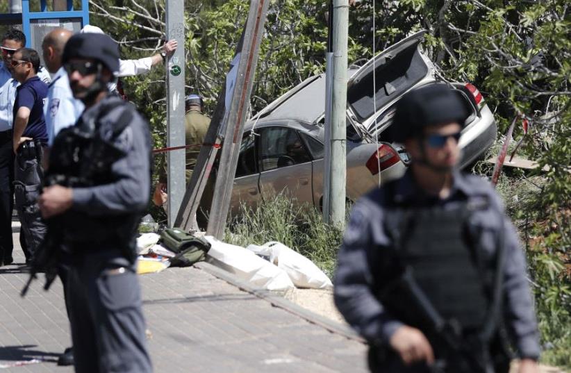 Israeli security forces gather at the site of a car ramming attack outside the Israeli settlement of Ofra, north of the Palestinian city of Ramallah, on April 6, 2017 (photo credit: THOMAS COEX / AFP)