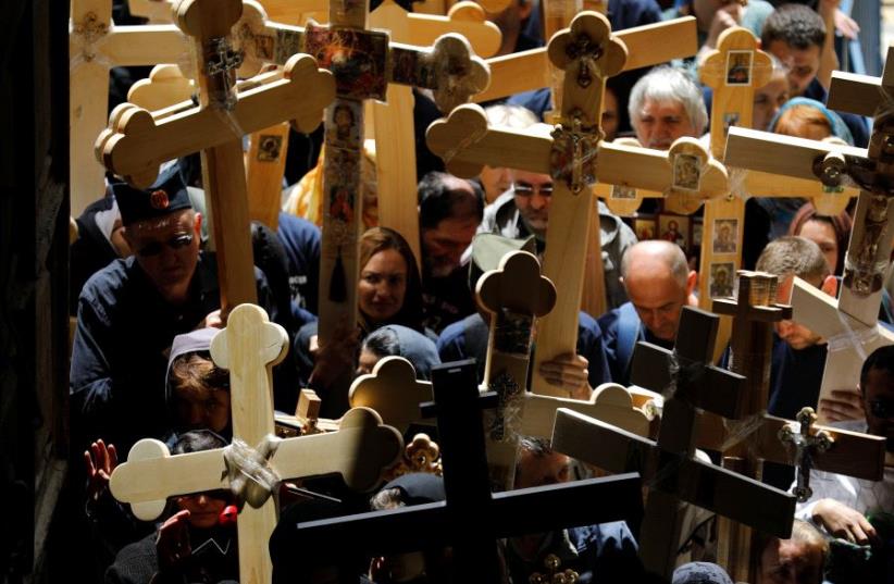 Worshippers carry crosses during a Good Friday procession as they enter the Church of Holy Sepulchre in Jerusalem's Old City April 14, 2017 (photo credit: REUTERS)