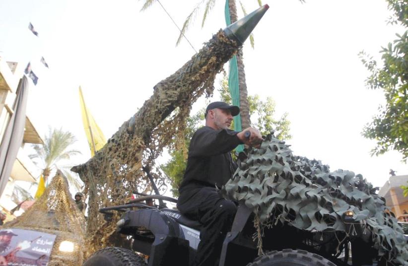 A Hezbollah member drives a 4-wheel motorbike mounted with a mock rocket in southern Lebanon in 2015 (photo credit: REUTERS)
