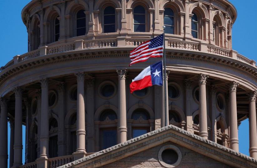 The US and Texas State flags fly over the Texas State Capitol in Austin (photo credit: REUTERS)