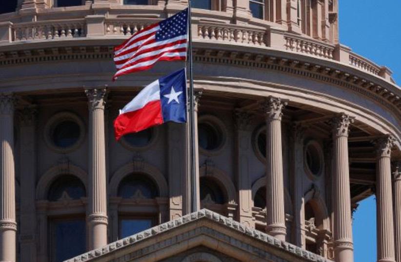 The US and Texas State flags fly over the Texas State Capitol in Austin (photo credit: REUTERS)