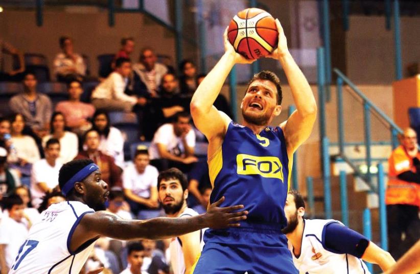 Maccabi Tel Aviv guard Gal Mekel (shooting) scored a team-high 14 points in last night’ 84-65 win over Maccabi Kiryat Gat, a victory that propelled the yellow-and-blue back atop the BSL standings (photo credit: UDI ZITIAT)