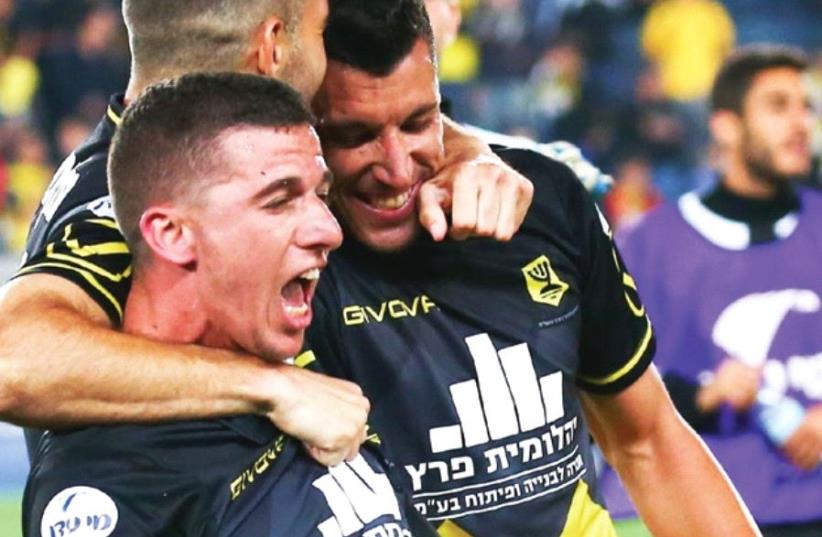 Beitar Jerusalem forward Idan Vered (front) celebrates with teammates after scoring a dramatic winner to give his team a 2-1 victory over Maccabi Petah Tikva last night at Teddy Stadium (photo credit: DANNY MAROM)