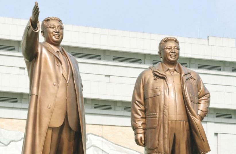 Bronze statues of North Korea’s late founder Kim Il-sung and late leader Kim Jong Il as they offer flowers to the statues in Pyongyang this week, to mark the 85th anniversary of the founding of the Korean People’s Army (photo credit: REUTERS)