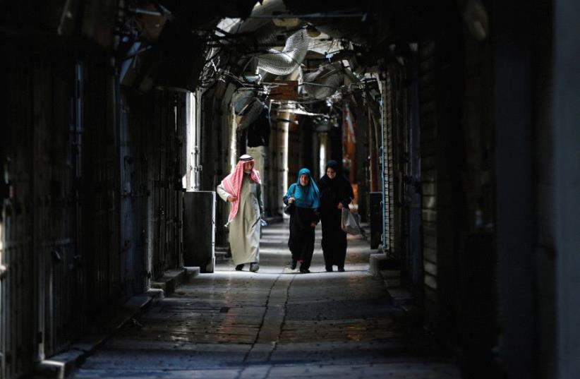 ARABS WALK passed closed shops in Jerusalem’s Old City. ‘Some 350,000 people – about one-third of Jerusalemites – are not even citizens of the country in which they are living,’ writes the author (photo credit: REUTERS)