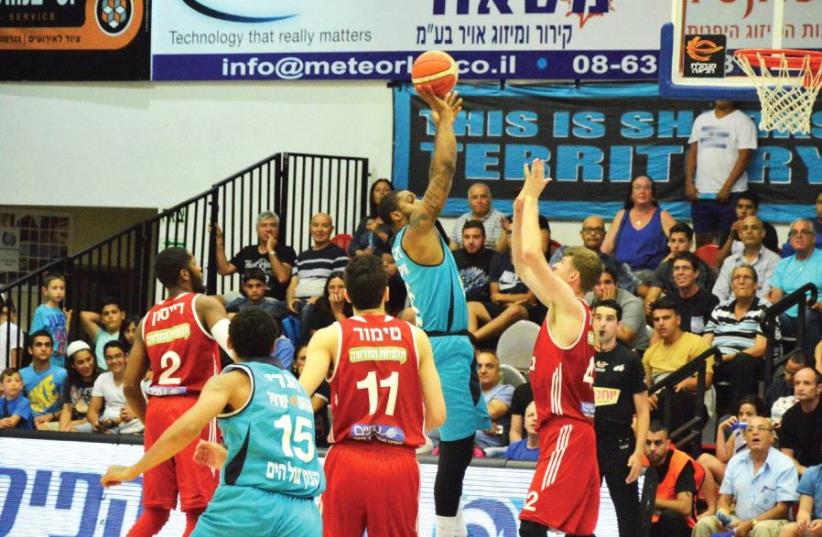 Hapoel Eilat forward Will Daniels (center) scores two of his 16 points during last night’s 86-80 overtime win against Hapoel Jerusalem (photo credit: FRANCISCO DI STASIO/BSL)