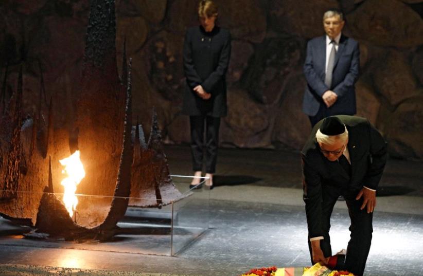 German President Frank-Walter Steinmeier touches a wreath during a ceremony commemorating the six million Jews killed by the Nazis in the Holocaust, in the Hall of Remembrance at Yad Vashem Holocaust memorial in Jerusalem (photo credit: REUTERS)