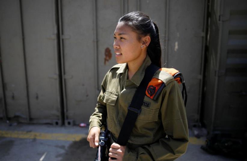 Joana Chris Arpon, an Israeli soldier from a search and rescue unit, whose parents immigrated from the Philippines, looks on during a drill at Tzrifin military base in central Israel May 10, 2017 (photo credit: REUTERS)