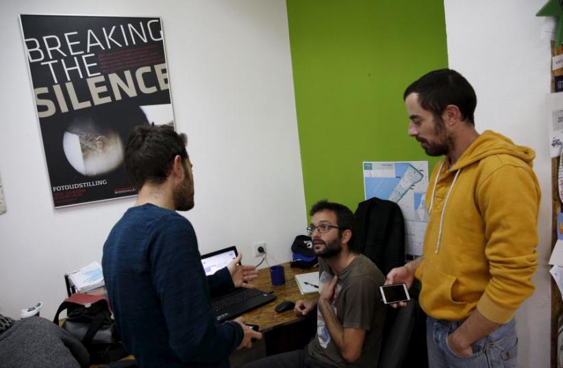 Employees work at the offices of "Breaking the Silence" in Tel Aviv, Israel (photo credit: REUTERS)