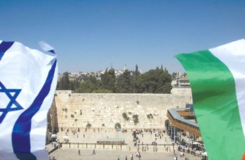 Israeli and Palestinian flags are seen waving in front of the Kotel (photo credit: REUTERS)