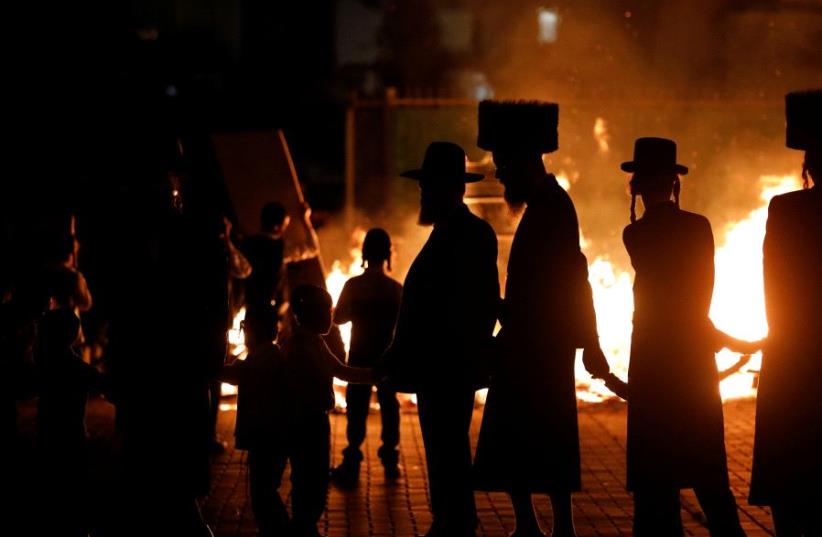 Ultra-Orthodox Jews dance around a bonfire as they celebrate the Jewish holiday of Lag Ba'Omer in the city of Ashdod, Israel May 13, 2017. (photo credit: REUTERS)