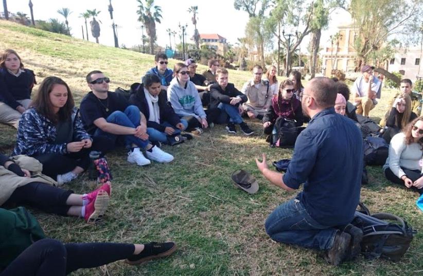 A group of Russian-speaking Birthright participants from Australia listen to their counselor while in Tel Aviv in December of 2016 (photo credit: RAMI TEPLITSKY)