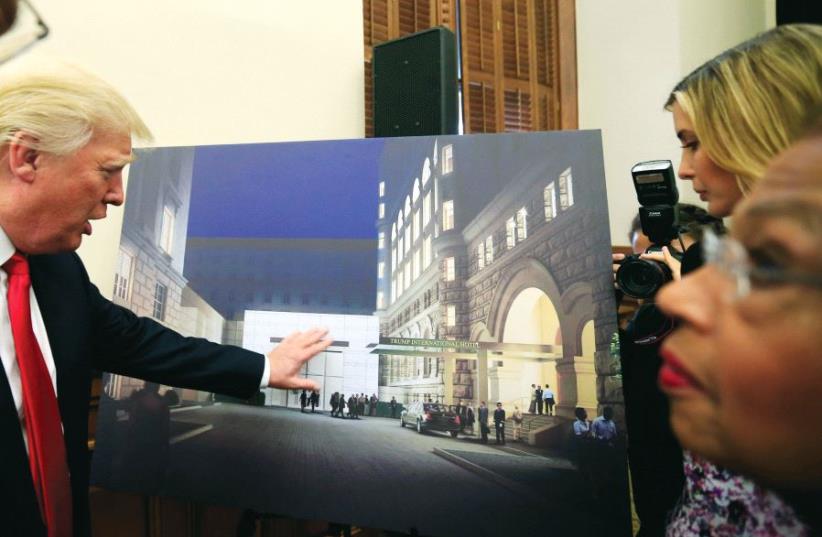 President Donald Trump, as a real-estate businessman in 2013, points to an architectural rendering of the Trump Organization’s redevelopment of the iconic Old Post Office building into a luxury hotel, in Washington (photo credit: REUTERS)
