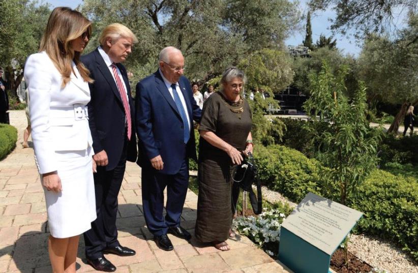 PRESIDENT REUVEN RIVLIN, US President Donald Trump and their wives read the plaque of a tree planted in honor of Trump’s visit at the President’s Residence in Jerusalem yesterday. (photo credit: MARK NEYMAN / GPO)