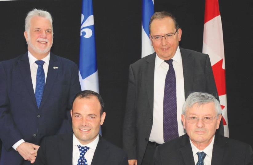 LEFT TO RIGHT: Quebec Premier Phillipe Couillard: Michael Penner, Hydro- Québec’s chairman of the board; Ofer Bloch, CEO of the IEC; and IEC senior vice president Yosi Shneck sign the collaboration agreement in Heftziba 22.5.2017. (photo credit: YOSSI WEISS / ISRAEL ELECTRIC CORPORATION)