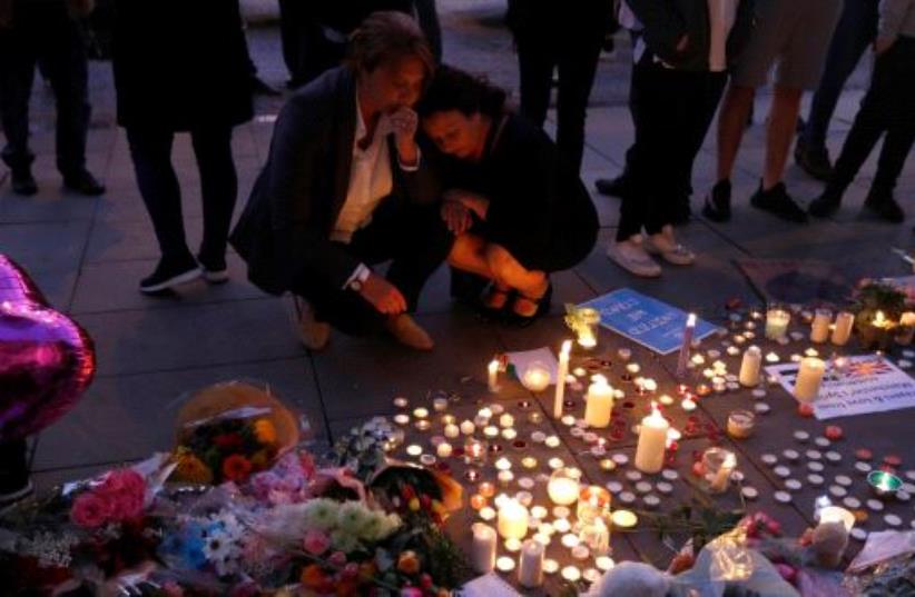 People pay their respects to the victims of the deadly suicide bombing in Manchester that took place during an Ariana Grande concert.  (photo credit: REUTERS)