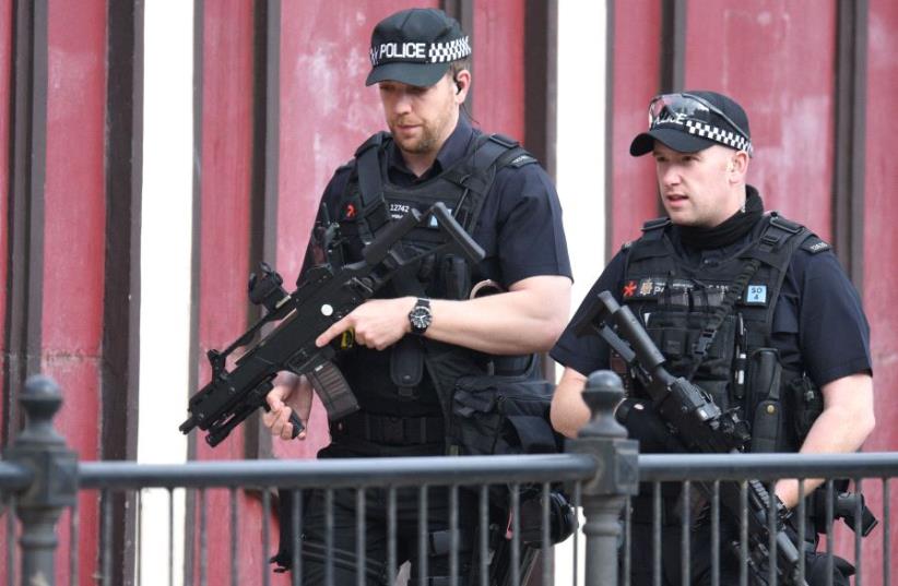 Armed police patrol near Manchester Arena following a deadly terror attack in Manchester, northwest England on May 23, 2017 (photo credit: OLI SCARFF / AFP)