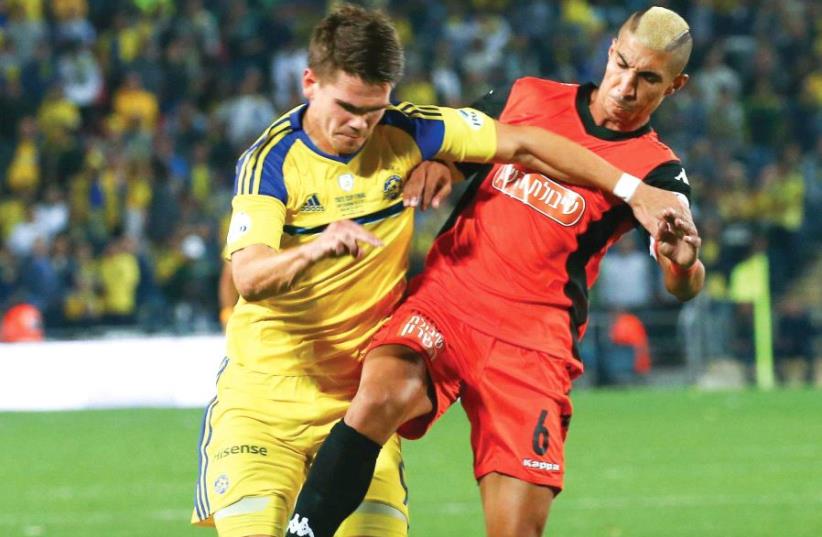 Maccabi Tel Aviv striker Vidar Orn Kjartansson (left) battles Bnei Yehuda defender Tal Kahila during last night’s State Cup final at Teddy Stadium. The match entered extra time after the first 90 minutes ended in a 0-0 draw (photo credit: DANNY MAARON)