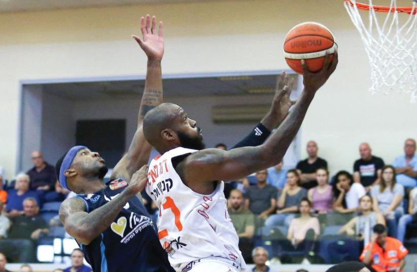 Maccabi Rishon Lezion center Charles Thomas (center) scores two of his team-high 18 points in last night’s 97-73 win over Hapoel Eilat in the BSL playoffs.  (photo credit: DANNY MAARON)