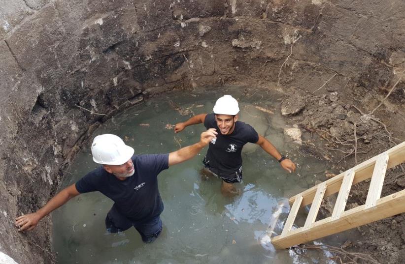 Israel Antiquities Authority guide Naftali Aizik and apprentice Faran Assaf Ramati work in the well (photo credit: MICHAL HABER/IAA)