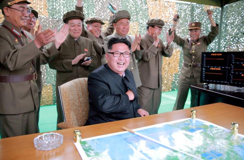 Kim Jong Un reacts during a test launch of ground-to-ground medium long-range ballistic rocket Hwasong-10 in this undated photo released June 23, 2016 (photo credit: REUTERS)