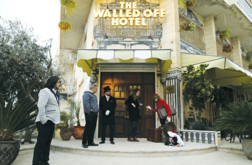 A statue of a chimpanzee bellboy graces the entrance of the Walled Off Hotel in Bethlehem (photo credit: REUTERS)