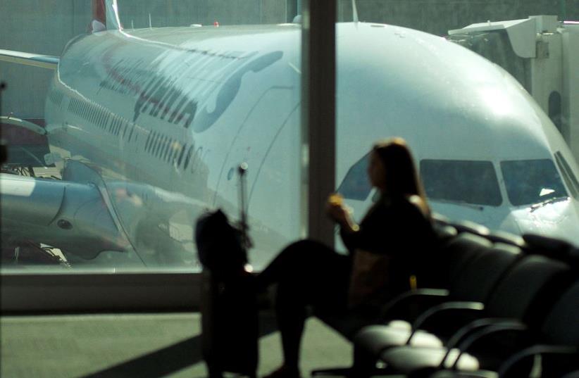 A passenger waits to board a Qantas domestic flight at Sydney airport in Australia (photo credit: REUTERS/JASON REED)