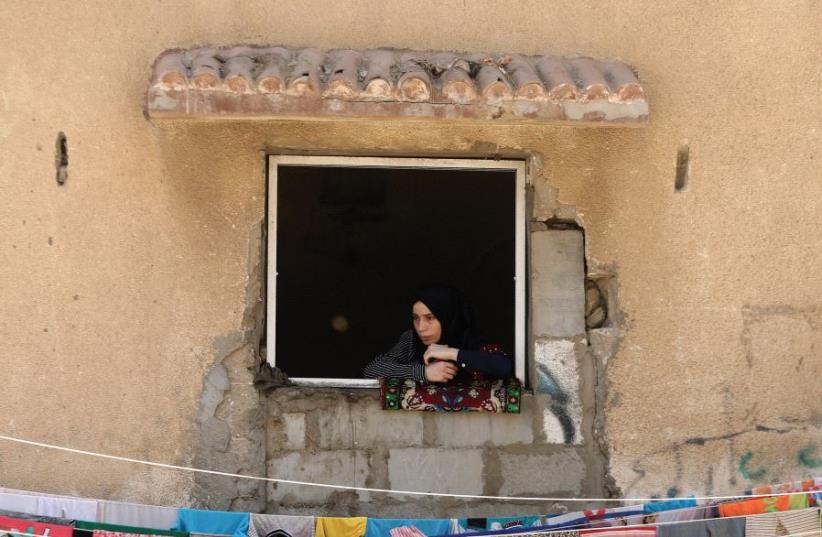 A WOMAN looks out a window in the Gaza Strip (photo credit: REUTERS)