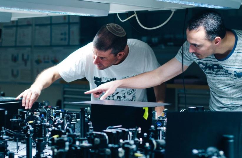 Prof. Hagai Eisenberg and graduate student Daniel Istrati study a single photon experiment at the Hebrew University's Quantum Information Science Center (photo credit: YITZ WOOLF FOR HEBREW UNIVERSITY)