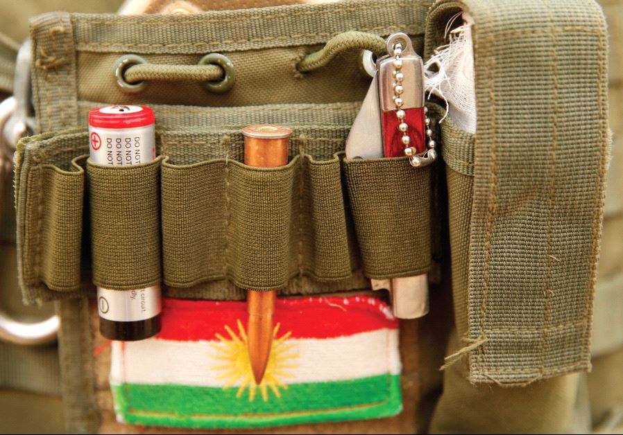 A BULLET and the Kurdistan flag are seen on a Peshmerga fighter’s vest during a battle with ISIS near Bashiqa, Iraq, last year. REUTERS 
