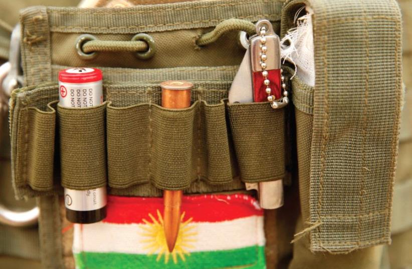A BULLET and the Kurdistan flag are seen on a Peshmerga fighter’s vest during a battle with ISIS near Bashiqa, Iraq, last year. (photo credit: REUTERS)