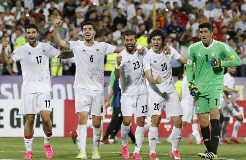 Iranian players celebrate after winning the 2018 World Cup qualifying football match between Iran and Uzbekistan at the Azadi Stadium in Tehran on June 12, 2017 (photo credit: ATTA KENARE / AFP)