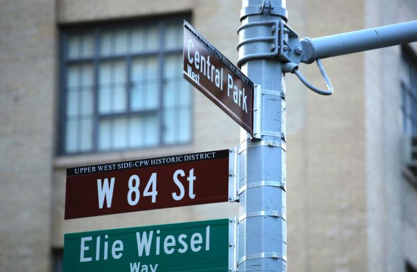 The street signs on the southwest corner of 84th Street and Central Park West are seen following a ceremony to permanently co-name the street with the late humanitarian and Nobel Peace Prize-winning name of Elie Wiesel, June 13, 2017 in New York. (photo credit: KENA BETANCUR / AFP)