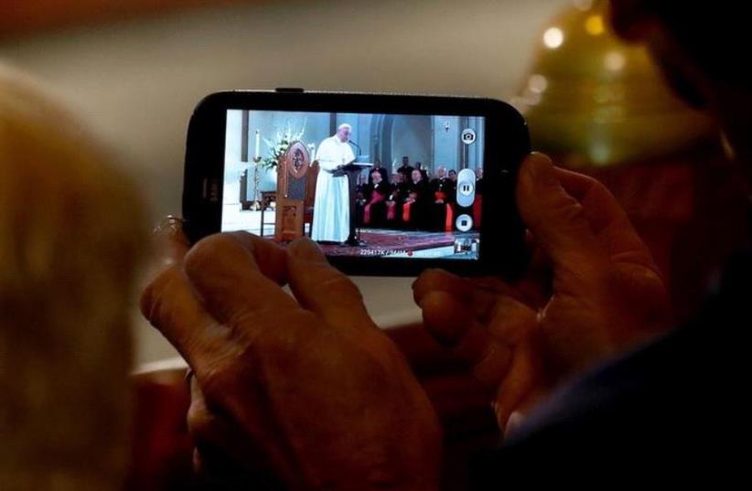 A member of the audience records Pope Francis as he speaks at St. Patrick's Catholic Church in Washington, September 24, 2015 (photo credit: REUTERS)