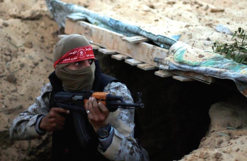 A hamas militant takes part in a tunnel attack simulation during a graduation ceremony in Rafah, in the southern Gaza Strip, last November (photo credit: REUTERS)