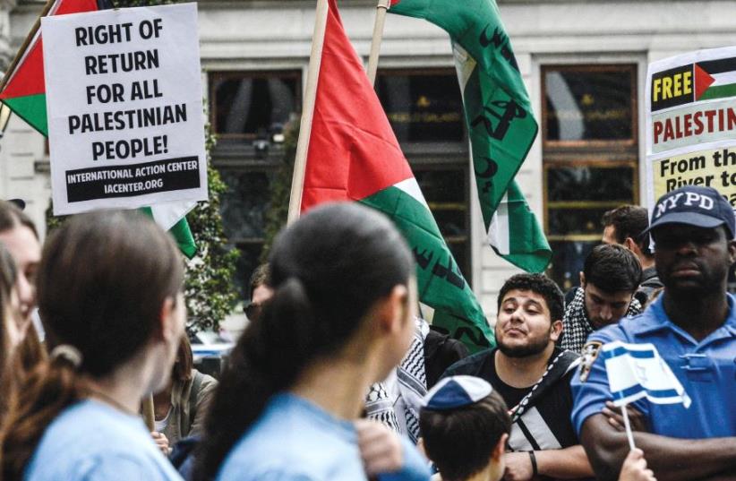 PEOPLE HOLDING Palestinian-rights placards taunt marchers in the Celebrate Israel Parade along New York’s Fifth Avenue earlier this month. (photo credit: STEPHANIE KEITH/REUTERS)