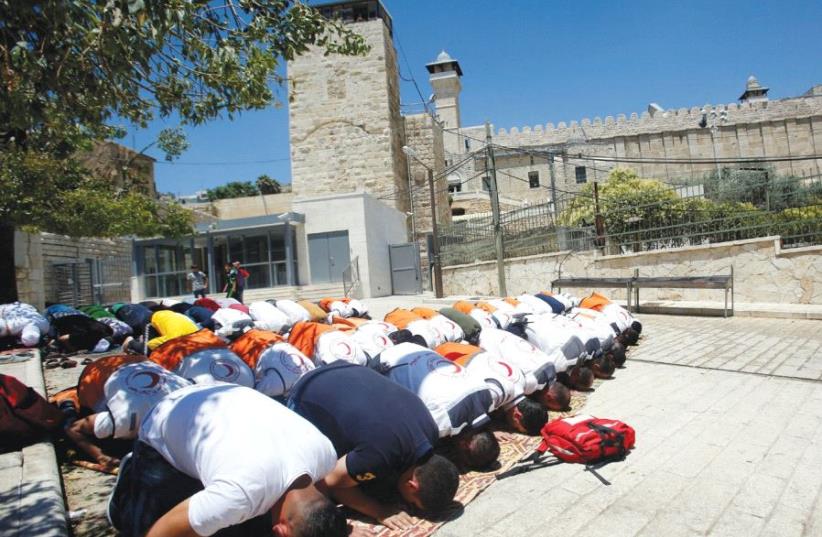 Muslims attend Friday prayers at the Tomb of the Patriarchs in Hebron, holy to both faiths as the burial site of Abraham (photo credit: MUSSA QAWASMA / REUTERS)