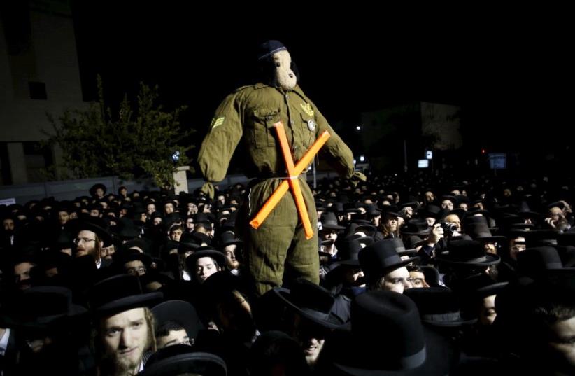 Ultra-Orthodox Jews attend a protest against a law calling for members of their community to serve in the army, in Jerusalem's Mea Shearim neighbourhood December 22, 2015. (photo credit: REUTERS/BAZ RATNER)