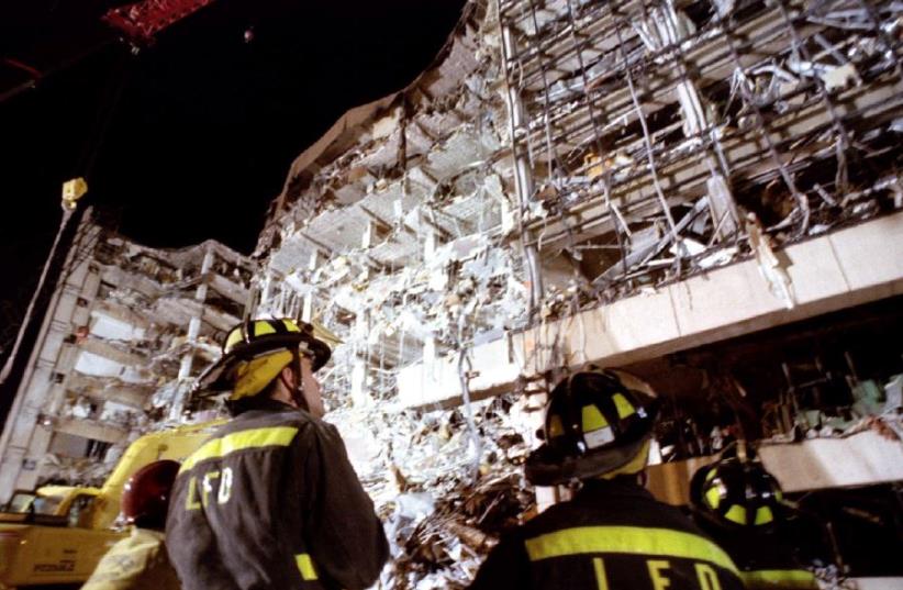 Firemen examine the wreckage of the federal building in downtown Oklahoma City that claimed the lives of 168 people. (photo credit: REUTERS)
