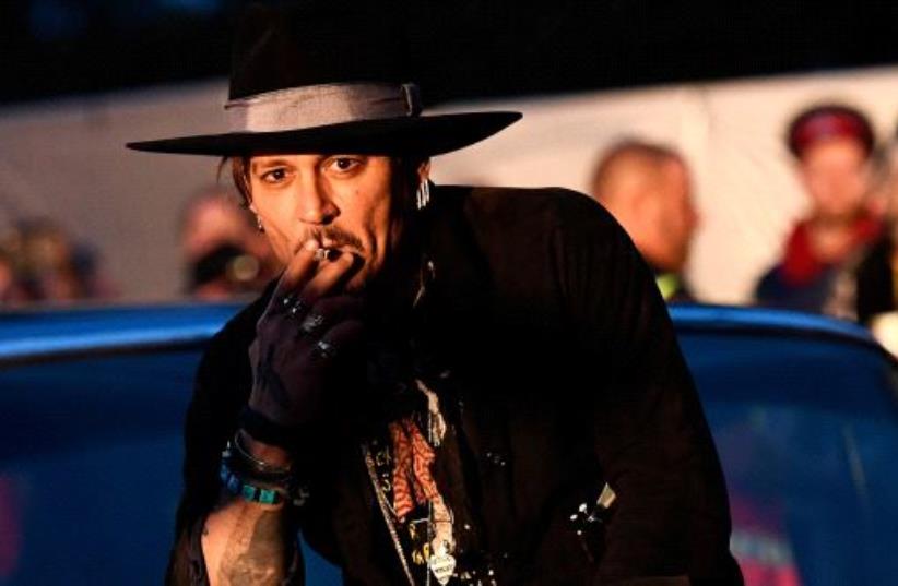 Actor Johnny Depp poses on a Cadillac before presenting his film The Libertine, at Cinemageddon at Worthy Farm in Somerset during the Glastonbury Festival in Britain, June 22, 2017. (photo credit: DYLAN MARTINEZ/REUTERS)