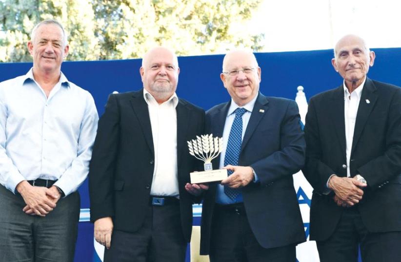 PRESIDENT REUVEN RIVLIN attends the President’s Prize for Volunteerism event at his official residence in Jerusalem on Wednesday along with former IDF chief of staff Lt.- Gen. (res.) Benny Gantz (left) head of the prize committee; honoree Itzik Zivan (second right), from Caesarea, who has been volun (photo credit: MARK NEYMAN / GPO)