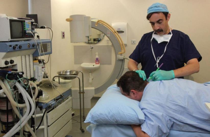 AN ISRAELI DOCTOR examines a patient in this illustrative photo. (photo credit: MARC ISRAEL SELLEM/THE JERUSALEM POST)
