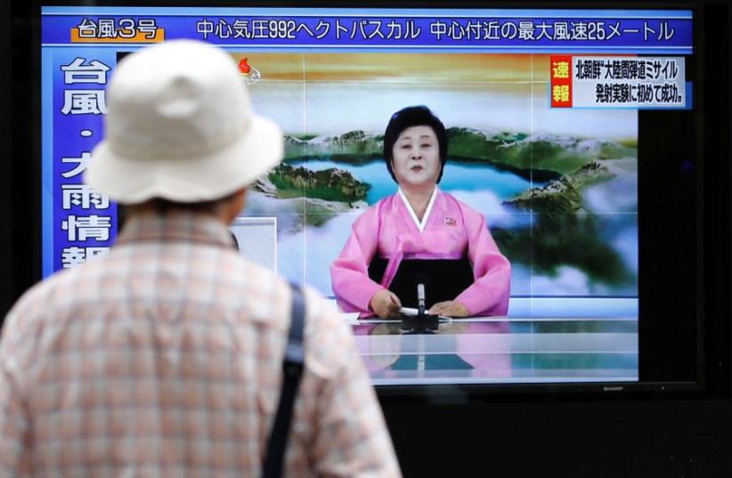 A man looks at a street monitor showing news of North Korea firing a ballistic missile in Tokyo, Japan, July 4, 2017. (photo credit: REUTERS/TORU HANAI)