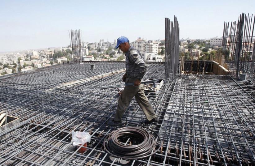 A Palestinian laborer works in the West Bank [Illustrative] (photo credit: REUTERS)