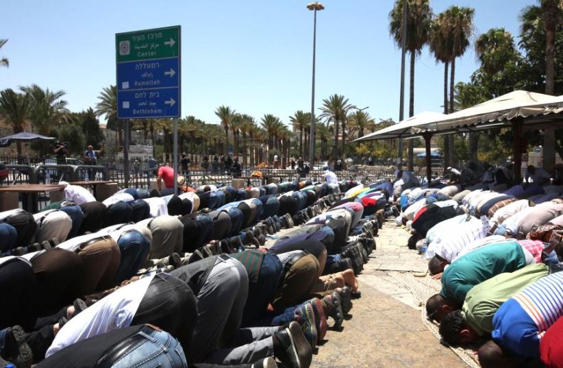 Muslims pray on the street outside the Old City (photo credit: MARC ISRAEL SELLEM/THE JERUSALEM POST)